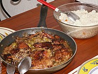 Yassa, sebuah hidangan yang populer di Afrika Barat, dengan bahan baku ayam atau ikan. Gambar ini merupakan yassa dari ayam.