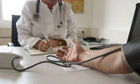 Doctor takes patients blood pressure-detail