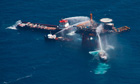 Boats spray water to extinguish a fire on an oil and gas platform off the Louisiana coast