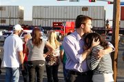 Bystanders react as emergency personnel work the scene where a trailer carrying wounded veterans in a parade was struck by a train in Midland, Texas. Photo / AP