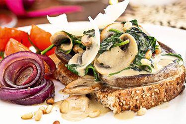 Field mushrooms with spinach cream and pine nuts