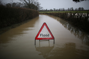 A council sign sits in flood water on a road near Lingfield in England. Photo / Getty Images