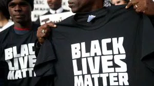 SAN FRANCISCO, CA - DECEMBER 18:  A protestor holds a black lives matter t-shirt during a "Hands Up, Don't Shoot" demonstration in front of the San Francisco Hall of Justice on December 18, 2014 in San Francisco, California. Dozens of San Francisco public attorneys and activists staged a "Hands Up, Don't Shoot" demonstration to protest the racial disparities in the criminal justice system following the non-indictments of two white police officers who killed unarmed black men in Missouri and New York.  (Photo by Justin Sullivan/Getty Images)