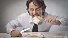 Symbolbild: Ein geldgieriger Geschäftsmann isst Banknoten
