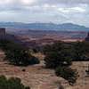 a view of canyons with mountains in the background