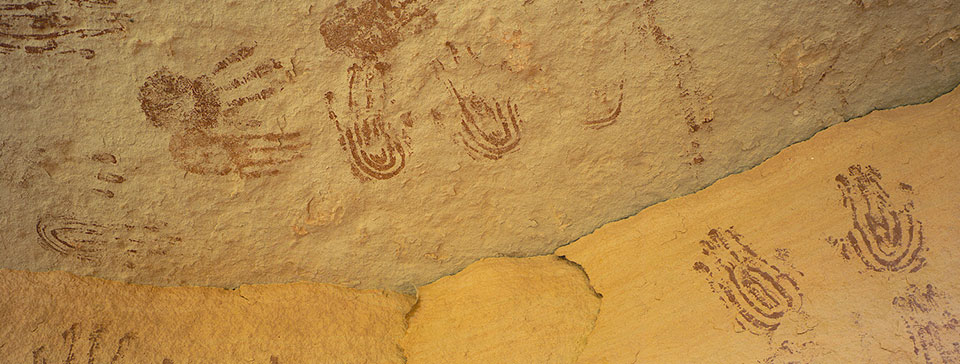 brown handprint shapes on a tan rock wall