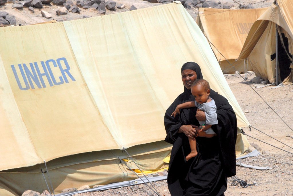 Somali woman carrying her child as she walks past UN-donated tents at a refugee camp 150 km west of Yemen's southern city of Aden. (Photo: Archive/EPA/Yahya Arhab)