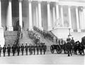 A departure ceremony held on the center steps at the United States Capitol Building as honor guards carry the coffin of the Unknown Soldier of World War I to limbers and caissons, 1921.