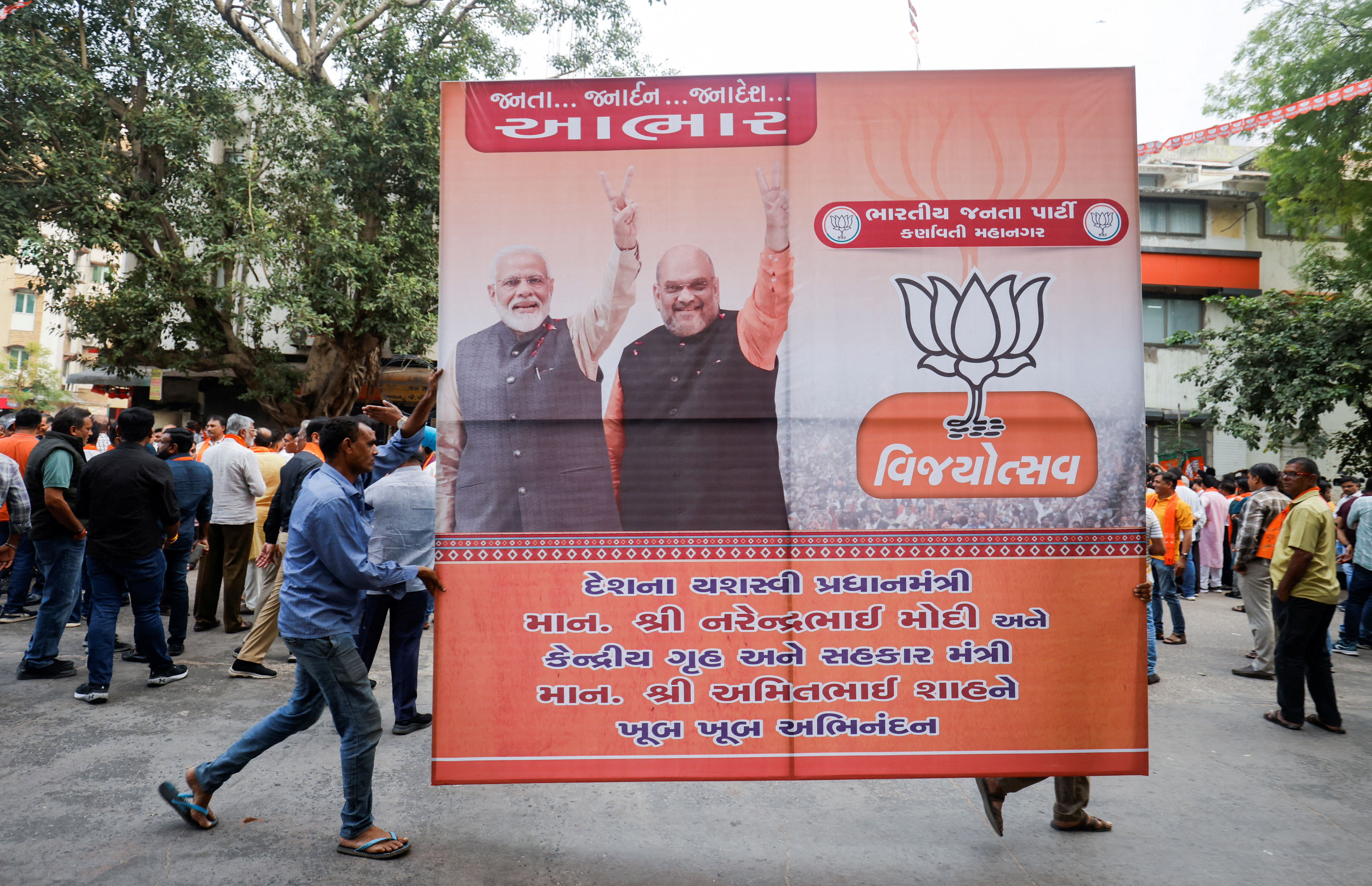 FILE PHOTO: Supporters of India's ruling Bharatiya Janata Party (BJP) carry a hoarding of Indian Prime Minister Narendra Modi and Union Minister of Home Affairs Amit Shah for celebrations in Ahmedabad
