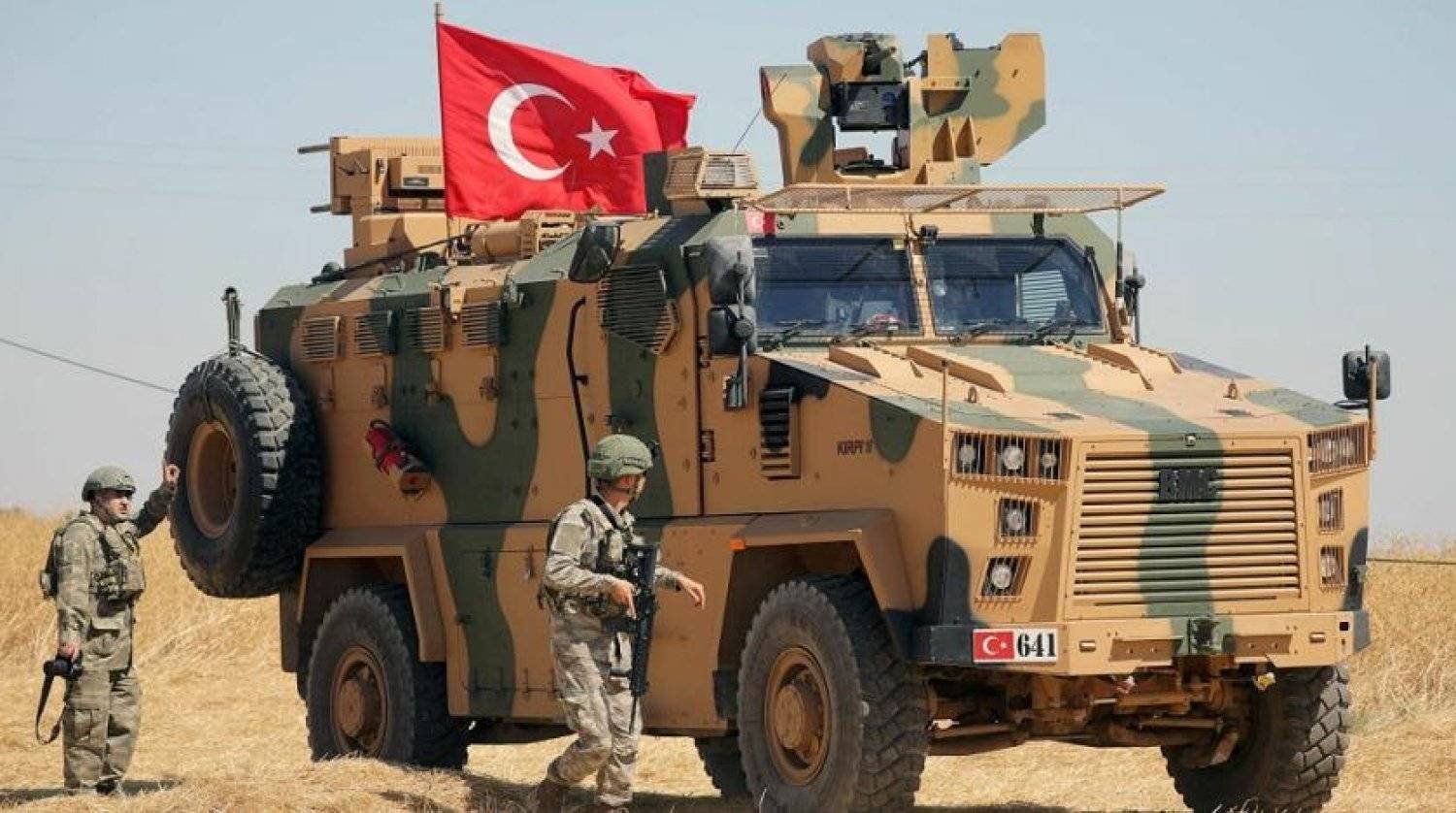 Turkish soldiers walk near their vehicle. Reuters