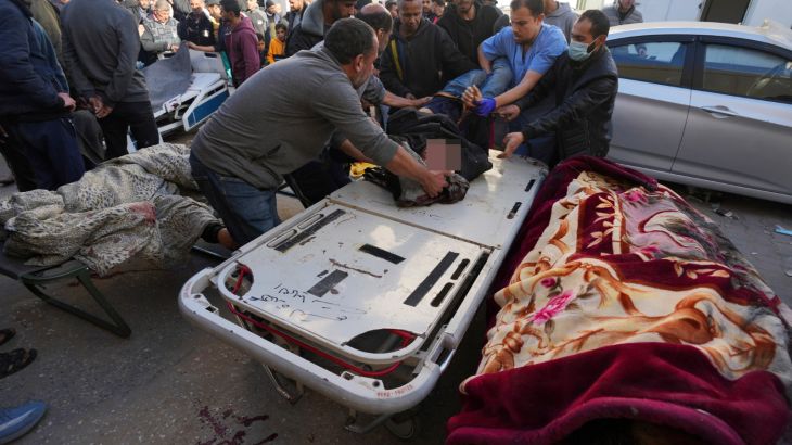 Palestinians bring people killed after an Israeli strike hit a building next to the Al-Aqsa Hospital in Deir al Balah