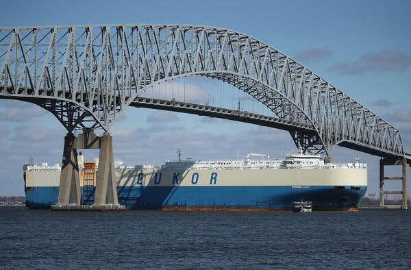A ship passes under a bridge.