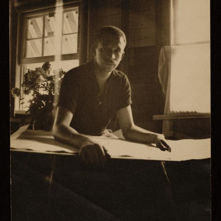 Photograph of Charles Henry Alston sitting in his studio with paper on his lap