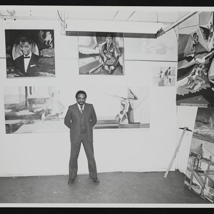 Photograph of Norman Parish with artwork standing in Parish Gallery