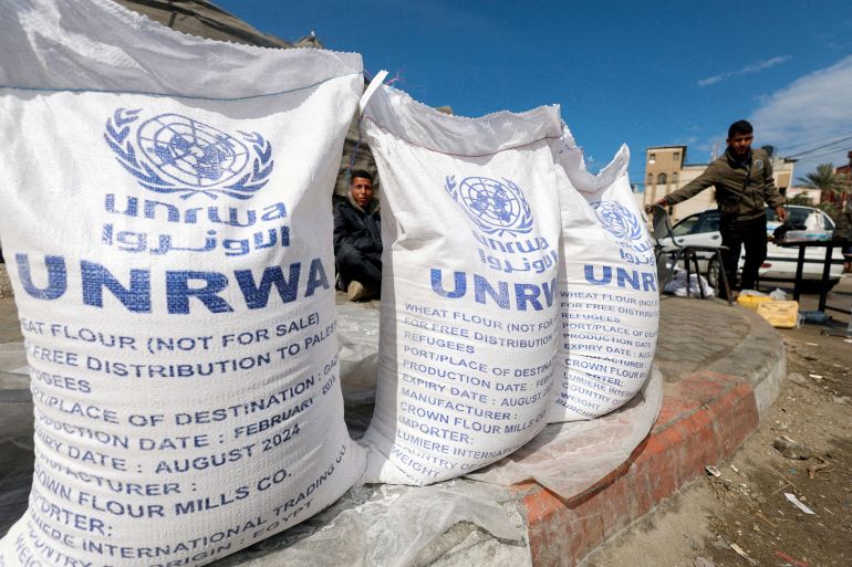 Displaced Palestinians wait to receive United Nations Relief and Works Agency (UNRWA) aid