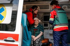 Paramedics help wounded local resident at a site of a Russian air strike in Kharkiv, Ukraine [Sofiia Gatilova/Reuters]