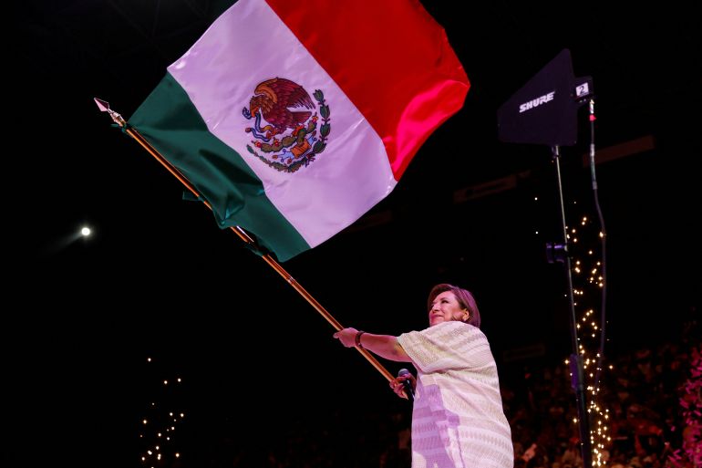 Xochitl Galvez waves a Mexican flag from the stage of her final campaign rally in 2024.