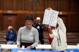 An Electoral Commission of South Africa (IEC) official holds up a marked ballot during the vote counting process at the Norwood school polling station in Durban [Gianluigi Guercia/AFP]