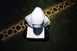 High Angle View Of Girl Wearing Hijab Reading Koran During Ramadan