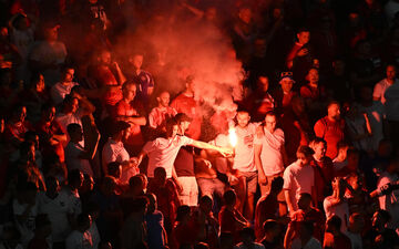 Des engins pyrotechniques en tribunes lors du match Danemark - Serbie en phase de groupes. Peter Kneffel/dpa