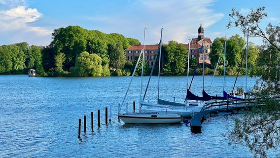 Segelboote liegen auf dem Eutiner See vor dem Schloss. © Norbert Schmäling Foto: Norbert Schmäling