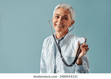 Take care of your health. A beautiful mature woman physician holds a stethoscope in her hand and is ready to check your health. 库存照片