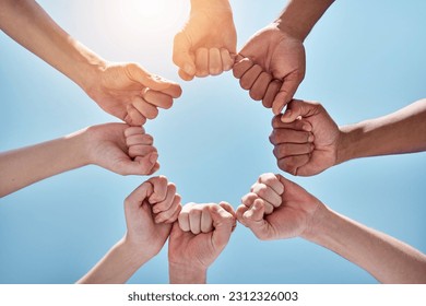 Team building, fist bump and hands in a circle together for unity, collaboration and connection. Solidarity, diversity and closeup of a group of multiracial people in a round shape by sky background. – Ảnh có sẵn