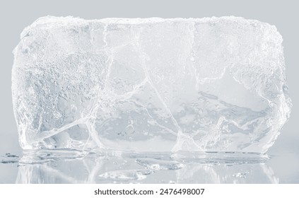 A textured block of transparent ice on a light gray background. 库存照片