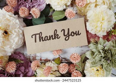 Thank You text message on paper card with flowers border frame on wooden background, fotografie de stoc