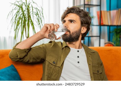 목마른 남자는 집에서 탈수를 막기 위해 천연 여과된 아쿠아 한 잔을 마시며 물을 마시게 한다. 역삼투 필터링하다 후 물. 좋은 생활 습관을 가진 남자, 건강, 체중 감소 스톡 사진