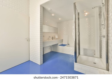 This modern bathroom, located in schapenburgpad, amsterdam, features bright white tiles, a shower, and a striking blue floor, creating a clean and vibrant look – Ảnh có sẵn