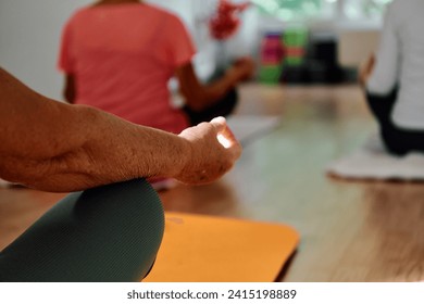 In this sunlit space, a senior woman's hand gracefully engages in various yoga poses, embodying the essence of active aging, health, and inner peace Foto stock