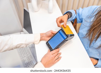 Top view of an unrecognizable woman paying with credit card in a beautician clinic Stockfotó