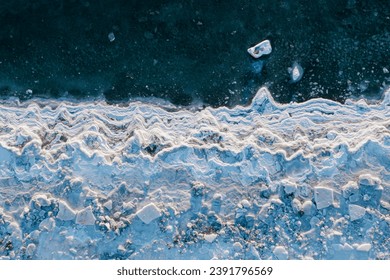凍てつく海のトップビュー。氷の多い海岸と海水中の氷流の冬の航空写真。極北の自然。寒い寒い冬の天気。過酷な北極気候。自然の背景。の写真素材