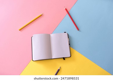 top view of Open notebook with blank pages and pencils on colorful background Adlı Stok Fotoğraf