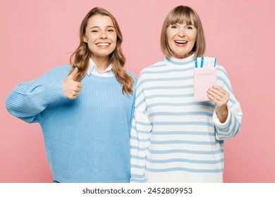 Traveler two woman parent mom, adult daughter wear casual clothes hold passport ticket isolated on plain pink background. Tourist travel abroad in free spare time rest getaway. Air flight trip concept Stock-foto