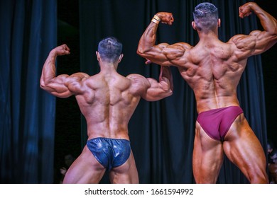 Two bodybuilders posing on the podium under the lights during the event Stock-foto