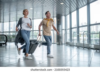 Two excited tourists hurrying to catch the flight Foto stock