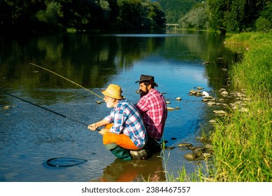 Two men friends anglers fishing. Flyfishing angler makes cast, standing in river water. Old and young fisherman. Foto stock