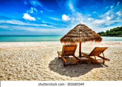 Vacation holidays background wallpaper - two beach lounge chairs under tent on beach. Sihanoukville, Cambodia Stock Photo