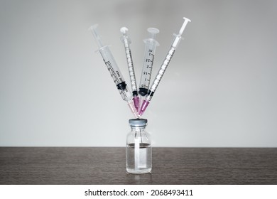A vaccine vial with 4 syringes. A fourth dose Covid-19 vaccine booster shot concept. Arkistovalokuva