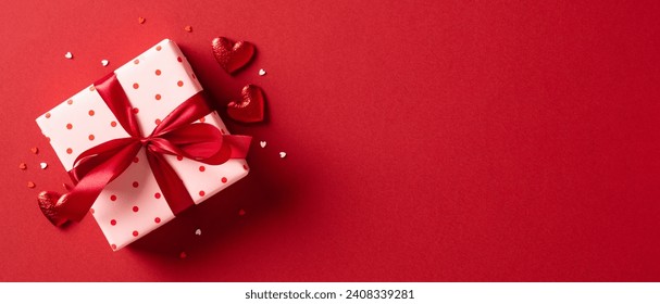 Valentine's day gift. Banner design with present box and hearts on red background. Stock Photo