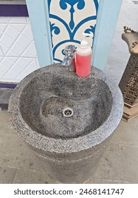 液体石鹸のボトルで石から手の洗面器を洗う屋外に置きます の写真素材