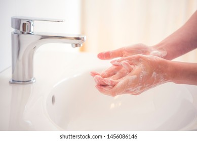 Washing hands with soap under the faucet with water. Hygiene concept. Stock Photo