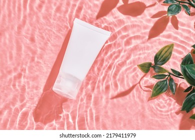 White cosmetic tube on the pink water surface. Blank label for branding mockup. Flat lay, top view. beauty spa medical skincare and cosmetic lotion bottle cream packaging product on pink background. ஸ்டாக் ஃபோட்டோ