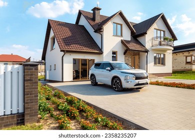花壇と花と白い家だけでなく、家の前に白い車。の写真素材