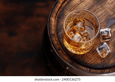 Whiskey glass with ice on a rustic barrel, a classic sip. With copy space – Ảnh có sẵn
