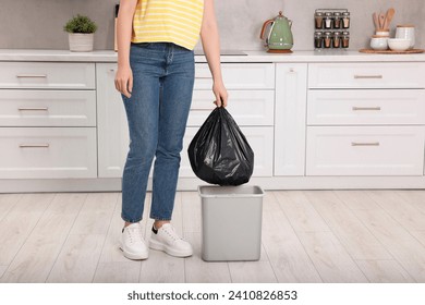 台所のゴミ箱からゴミ袋を出して持ち出す女性、接写の写真素材
