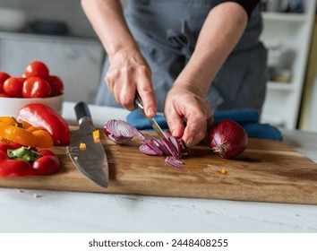 Woman is cutting red onions into slices on a cutting board Arkistovalokuva