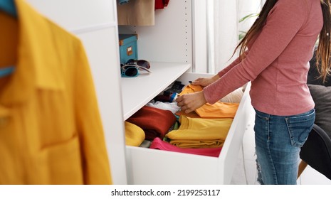 Woman getting ready, she is taking a t-shirt from a drawer Stock Photo